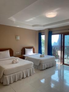 twee bedden in een kamer met een raam bij Garden View Resort Tonsai in Tonsai Beach