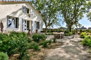 Casa blanca con mesa y sillas en Villa Montel - Havre de paix à Graveson, en Graveson