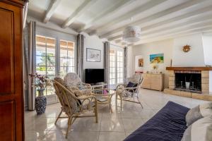 een woonkamer met een tafel, stoelen en een televisie bij Villa de la mer - Bretignolles in Brétignolles-sur-Mer