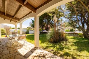 een patio met 2 stoelen en een tafel in de tuin bij Villa de la mer - Bretignolles in Brétignolles-sur-Mer