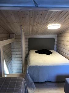 1 dormitorio con 1 cama en una habitación de madera en Villa Meriheinä, en Pori