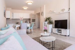een woonkamer met een witte bank en een keuken bij Oceanview Oasis in Varna