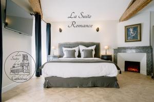 a bedroom with a large bed and a fireplace at Les Suites de la Cathédrale in Albi