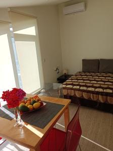 a room with a bed and a table with a bowl of fruit at Rose in Heraklio