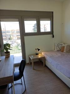 une chambre avec un lit, une table et des fenêtres dans l'établissement Rose, à Héraklion