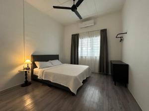 a bedroom with a bed and a ceiling fan at Mersing 1845 homestay in Mersing