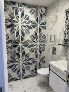 baño con aseo y pared de azulejos en Sofia Apartment, en Sofía