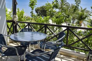 a table and chairs on a balcony with trees at Yiallos Village C107 in Larnaka