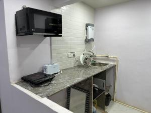 a room with a counter with a sink and a phone at Ravish Apartment, Juhu in Mumbai