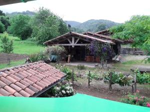 a house with a tiled roof in a garden at Location en Pré montagne pyrénéenne in Saleich