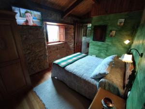 een slaapkamer met een bed en een tv aan de muur bij Río da Cruz in Cariño