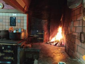 een bakstenen oven met een vuur erin bij Río da Cruz in Cariño