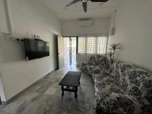a living room with a couch and a tv at Mersing 1845 homestay in Mersing