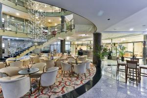 un restaurant avec des tables et des chaises dans un bâtiment dans l'établissement Kings Park Hotel, à Podgorica