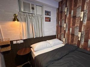 a small bedroom with a bed and a window at 7 guest house in Hong Kong