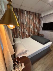 una camera da letto con un letto e un tavolo con una lampada di 7 guest house a Hong Kong