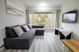 uma sala de estar com um sofá e uma mesa em Stylish 2BR Retreat - Near Station, Free Parking em Raynes Park