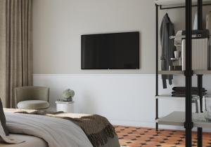 a bedroom with a tv on a white wall at Hotel Hirschen am See in Meilen