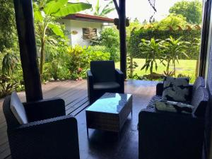a patio with two chairs and a table and chairs at Fare Anaiti Moorea in Iumaru
