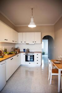 a kitchen with white cabinets and a wooden table at Naja's Studio in Souvala