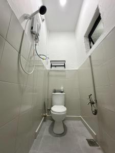 a bathroom with a white toilet in a room at Mersing 1845 homestay in Mersing