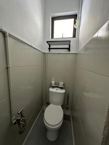 a small bathroom with a toilet and a window at Mersing 1845 homestay in Mersing
