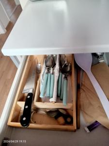 a drawer under a table filled with cooking utensils at Antwerpen OLIVIA Apartments in Antwerp