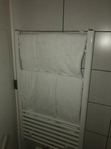 a stack of towels on a towel rack in a bathroom at Antwerpen OLIVIA Apartments in Antwerp