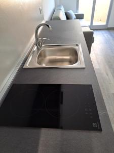 um balcão de cozinha com um lavatório e um tablet em Monolocale 2\4 posti presso Residence la Spiaggia em Marotta