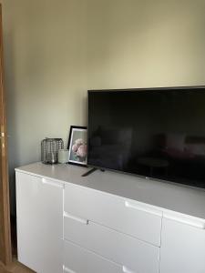 TV de pantalla plana grande en la parte superior de una cómoda blanca en Haus Anna, en Lemberg