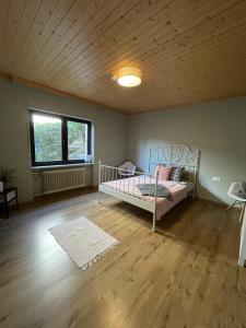 1 dormitorio con 1 cama en una habitación con techo de madera en Haus Anna, en Lemberg