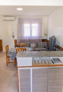 eine Küche und ein Wohnzimmer mit einem Tisch und einem Sofa in der Unterkunft Chalet Ebro barbacoa in Riba-roja d'Ebre