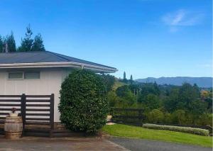 una casa con un arbusto al lado de una valla en Minden Meadows Retreat en Tauranga