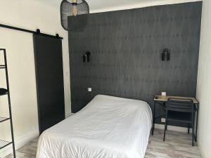 a bedroom with a bed and a black wall at Hôtel de La gare-Les Floralies in Poitiers