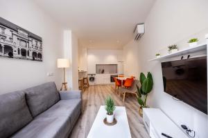 uma sala de estar com um sofá e uma mesa em Apartamentos Turísticos Gran Vía em Cartagena