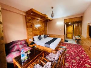 une chambre d'hôtel avec un lit et un canapé dans l'établissement santoshi Lodge, à Zirakpur