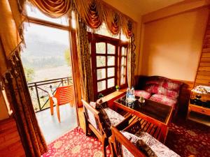 sala de estar con sofá, mesa y ventana en santoshi Lodge, en Zirakpur
