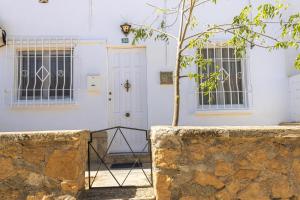 ein weißes Haus mit einem Baum davor in der Unterkunft Chalet Ebro barbacoa in Riba-roja d'Ebre