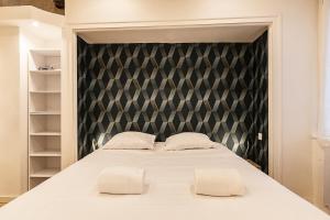 a bedroom with a large bed with two pillows at Ty Gwened - Centre Historique - Calme - Wifi in Vannes