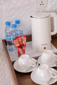 a table with a coffee maker and cups and milk bottles at Romhaey Kirirom Resort in Kampong Seila