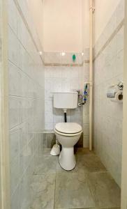 ein Bad mit einem WC und einer gefliesten Wand in der Unterkunft Pipacs Apartman in Szeged