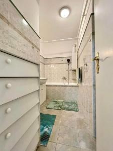 ein Badezimmer mit einer Dusche, einem Waschbecken und einer Badewanne in der Unterkunft Pipacs Apartman in Szeged