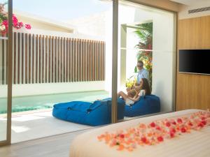 Explorar Koh Samui - Adults Only Resort and Spa في شاطئ مينام: وجود زوجين جالسين على أريكة في غرفة في الفندق