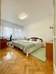 ein Schlafzimmer mit einem großen Bett und Holzboden in der Unterkunft Pipacs Apartman in Szeged