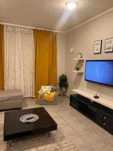 a living room with a large flat screen tv at شروق المدينة - مدينة الملك عبدالله الاقتصادية in King Abdullah Economic City