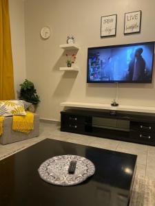 a living room with a flat screen tv on the wall at شروق المدينة - مدينة الملك عبدالله الاقتصادية in King Abdullah Economic City