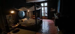 a bedroom with a canopy bed in a dark room at Love room Perpignan donjon 35mn de Perpignan in Perpignan