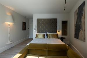 a bedroom with a large bed with a large headboard at Hotel Arancioamaro in Cannero Riviera