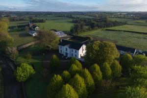 uma vista aérea de uma casa branca num campo em The Carriage Houses at Beechpark House em Bunratty