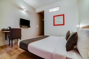 Habitación de hotel con cama y escritorio en Townhouse 361 Sarvar Hospitality Near Ascendas Park Square Mall, en Bangalore